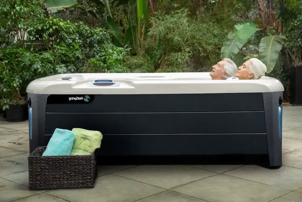 An elderly couple laying in a hot tub
